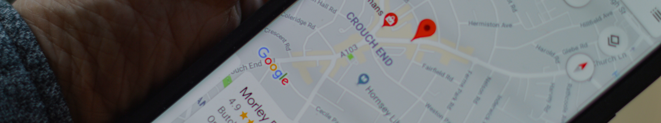 A smartphone on Google Maps showing a map pin.