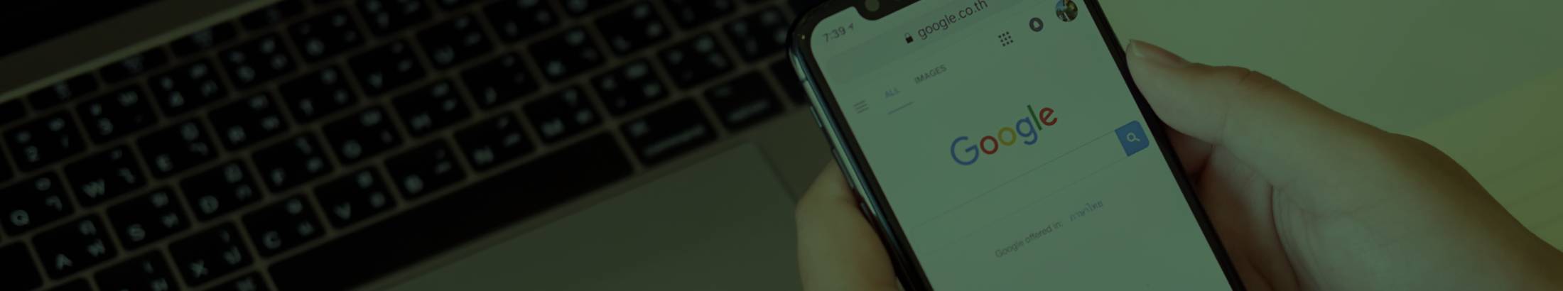 Hands holding a phone showing the Google Search UI