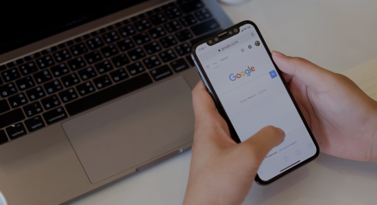 Hands holding a phone showing the Google Search UI