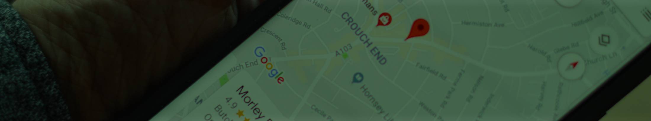 A smartphone on Google Maps showing a map pin.