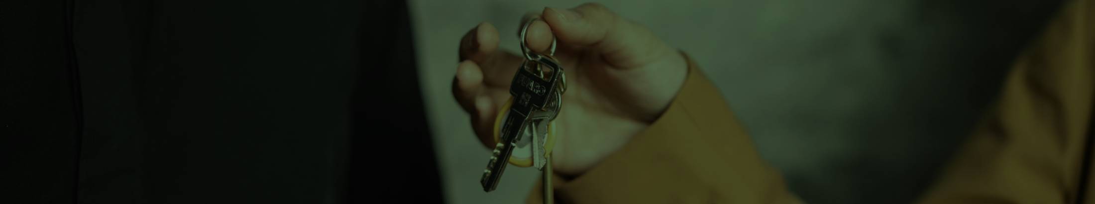 A person passing a set of keys to someone standing next to them