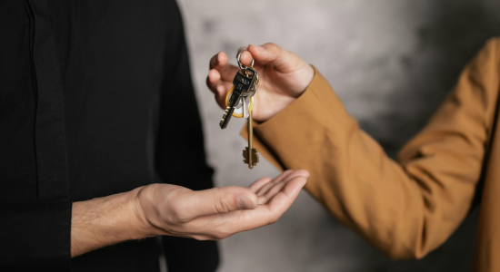 A person passing a set of keys to someone standing next to them