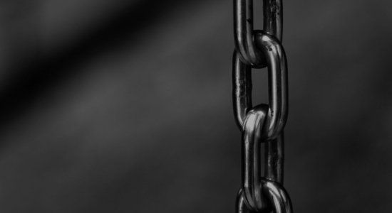 A close-up of chain links running from top to bottom of the frame