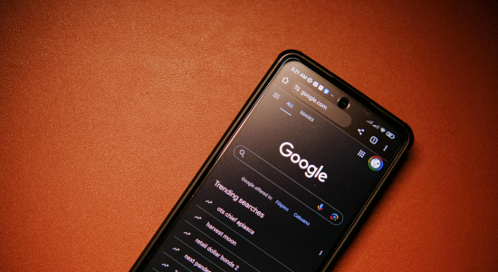 A smartphone on a red background, showing the Google Search UI.