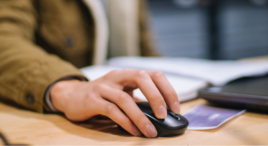 A photo focused on a hand using a computer mouse.