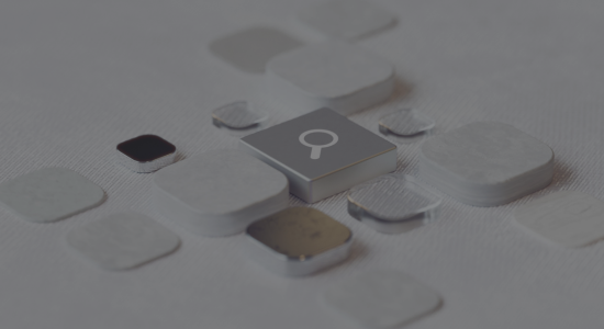 An abstract representation of AI search technology, using a variety of different tiles surrounding a central silver tile featuring the search magnifying glass.